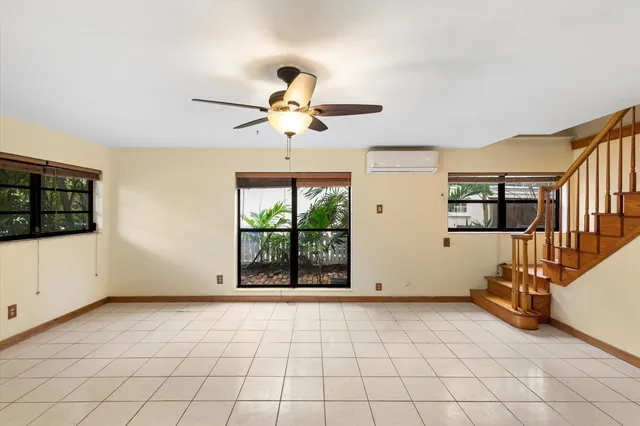 a view of a livingroom with a chandelier fan and windows