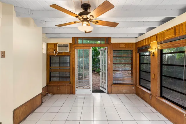 an empty room with windows and ceiling fan