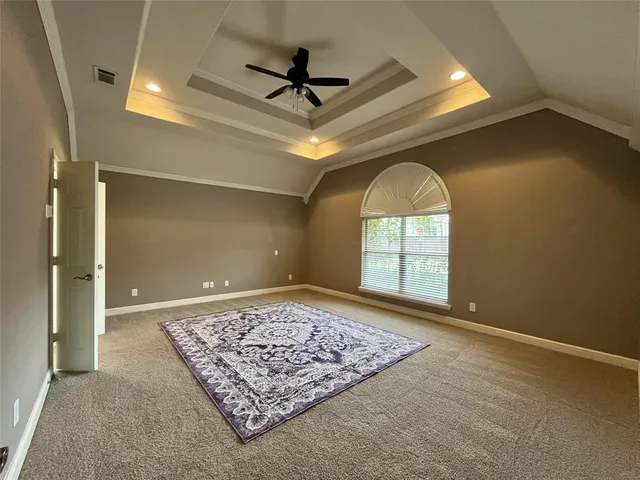 an empty room with windows and ceiling fan
