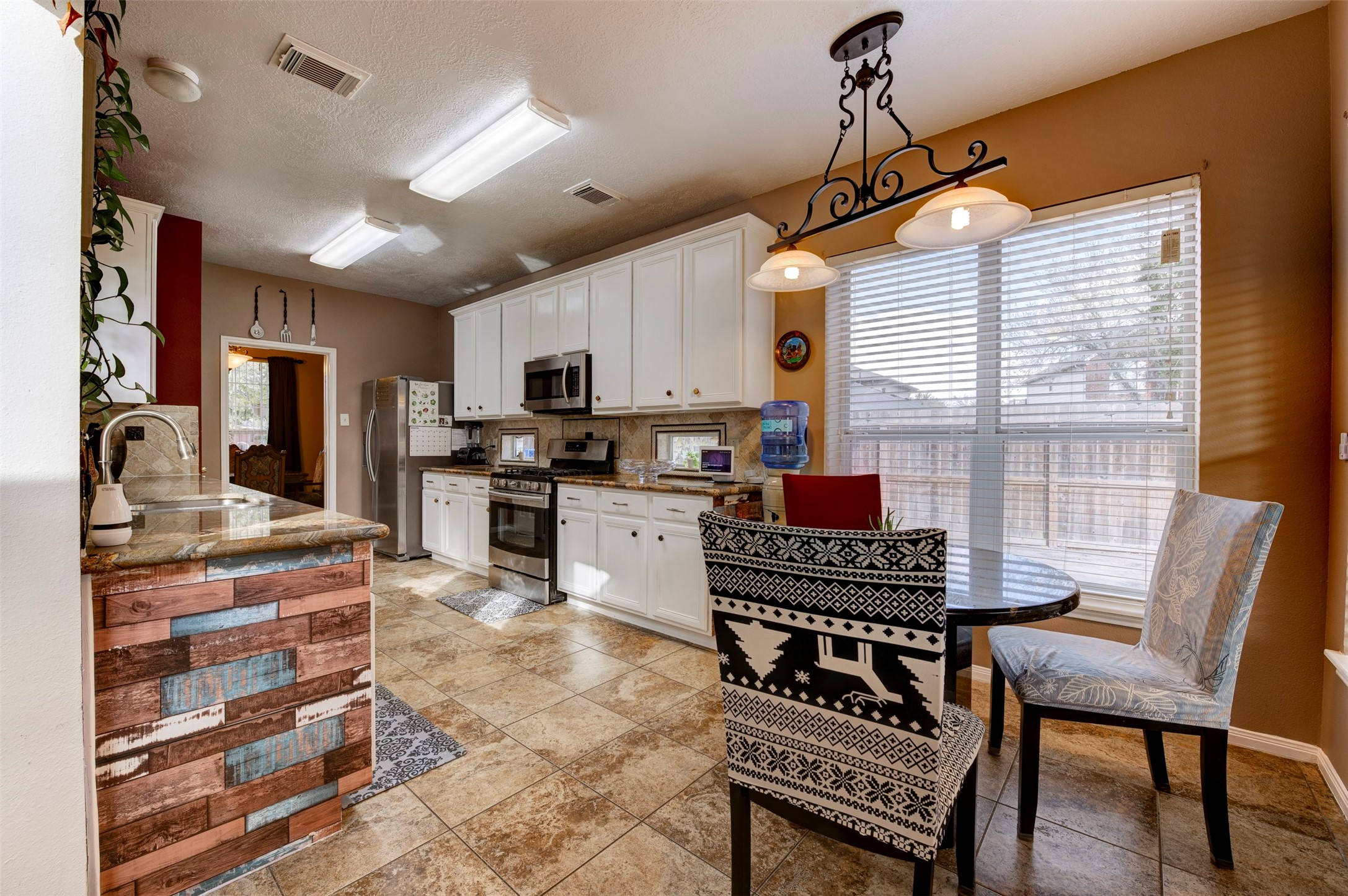 9214 Windy Spring Court Houston, TX 77089 - Photo 13 of 50 a kitchen with a dining table chairs and a refrigerator