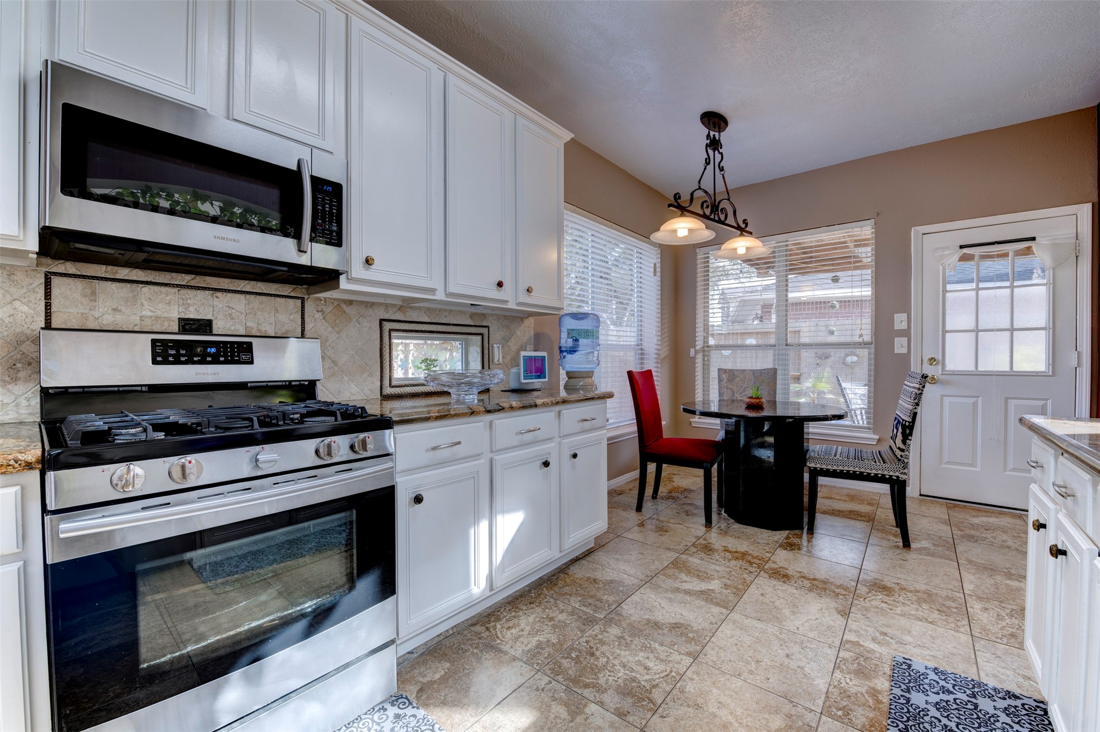 9214 Windy Spring Court Houston, TX 77089 - Photo 19 of 50 a kitchen with a stove a microwave and wooden cabinets