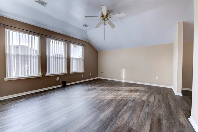 a view of a room with wooden floor and a window