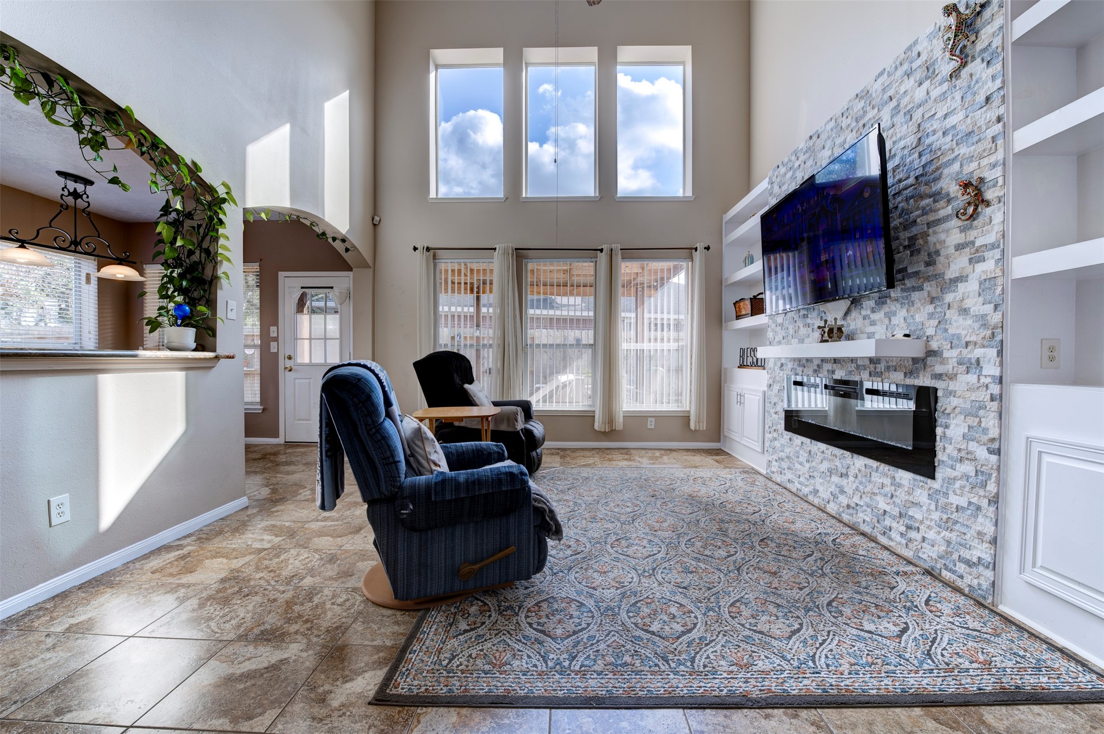 9214 Windy Spring Court Houston, TX 77089 - Photo 10 of 50 a living room with furniture a fireplace a flat screen tv and windows
