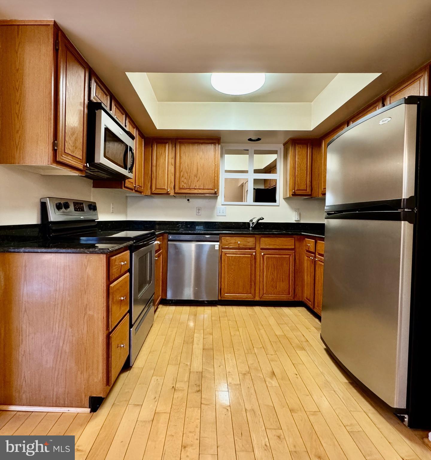 306 Leafcup Road Gaithersburg, MD 20878 - Photo 3 of 17 a kitchen with stainless steel appliances granite countertop a refrigerator a stove and a sink with wooden floor