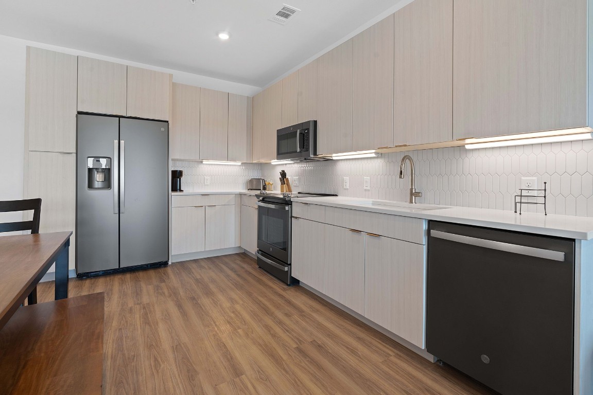 4802 South Congress Avenue, Unit 418 Austin, TX 78745 - Photo 14 of 24 a kitchen with a sink a refrigerator and cabinets
