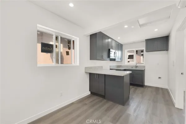 a large kitchen with a lot of counter space and wooden floor