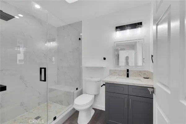 a bathroom with a sink a toilet and shower