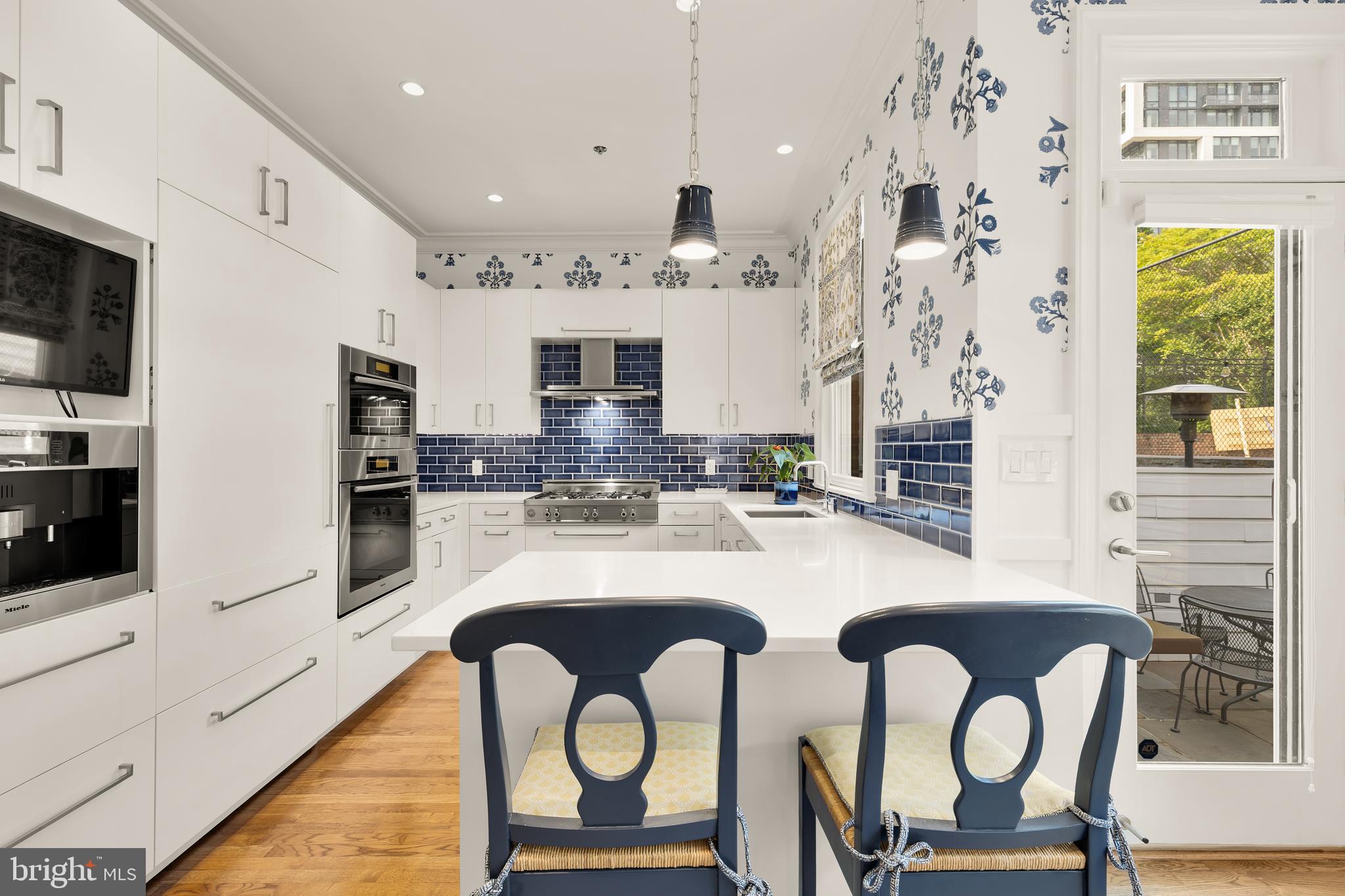 7449 Arlington Road Bethesda, MD 20814 - Photo 11 of 35 a kitchen with stainless steel appliances granite countertop a table chairs and a refrigerator