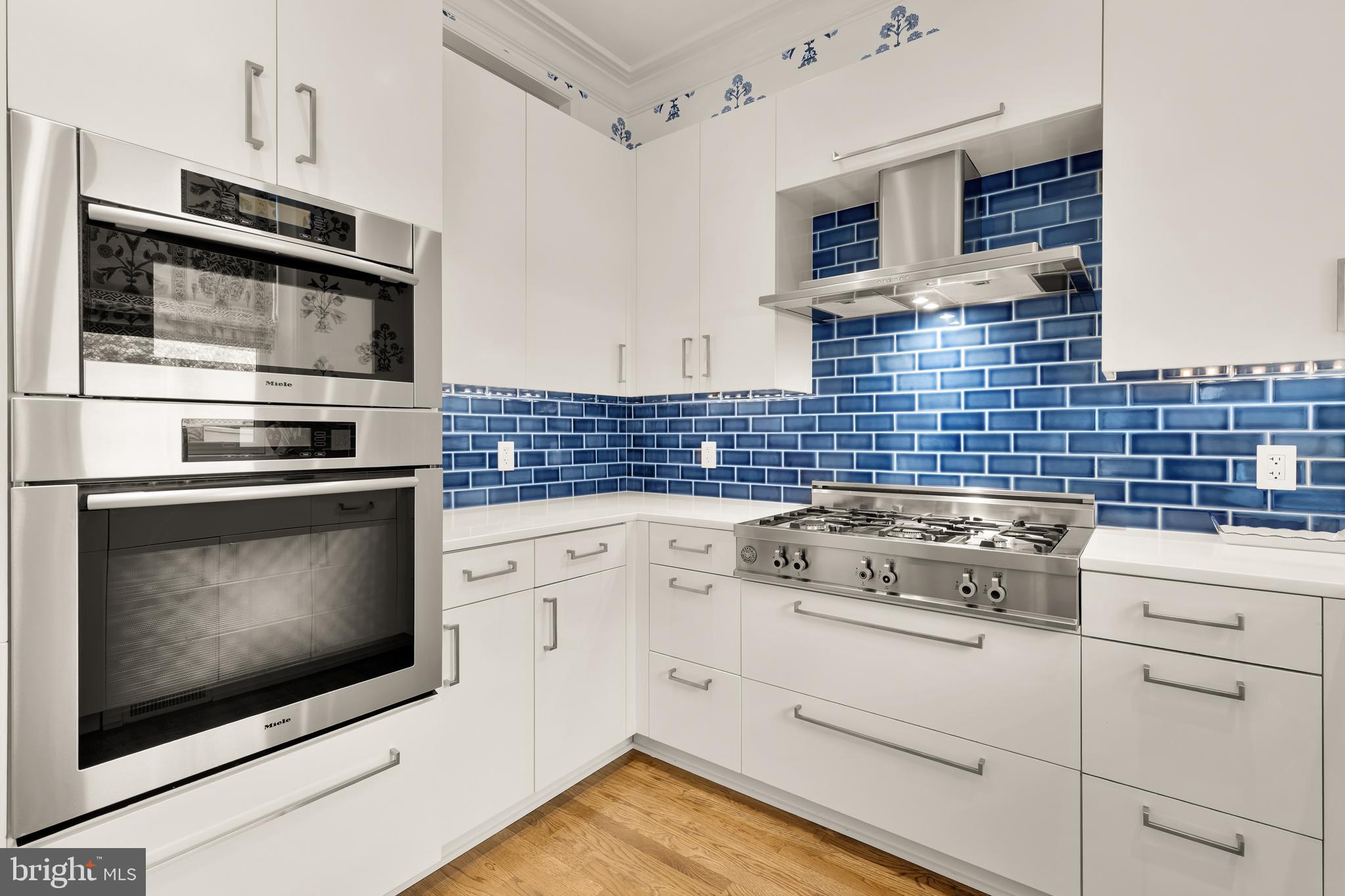 7449 Arlington Road Bethesda, MD 20814 - Photo 14 of 35 a kitchen with stainless steel appliances a stove microwave and cabinets
