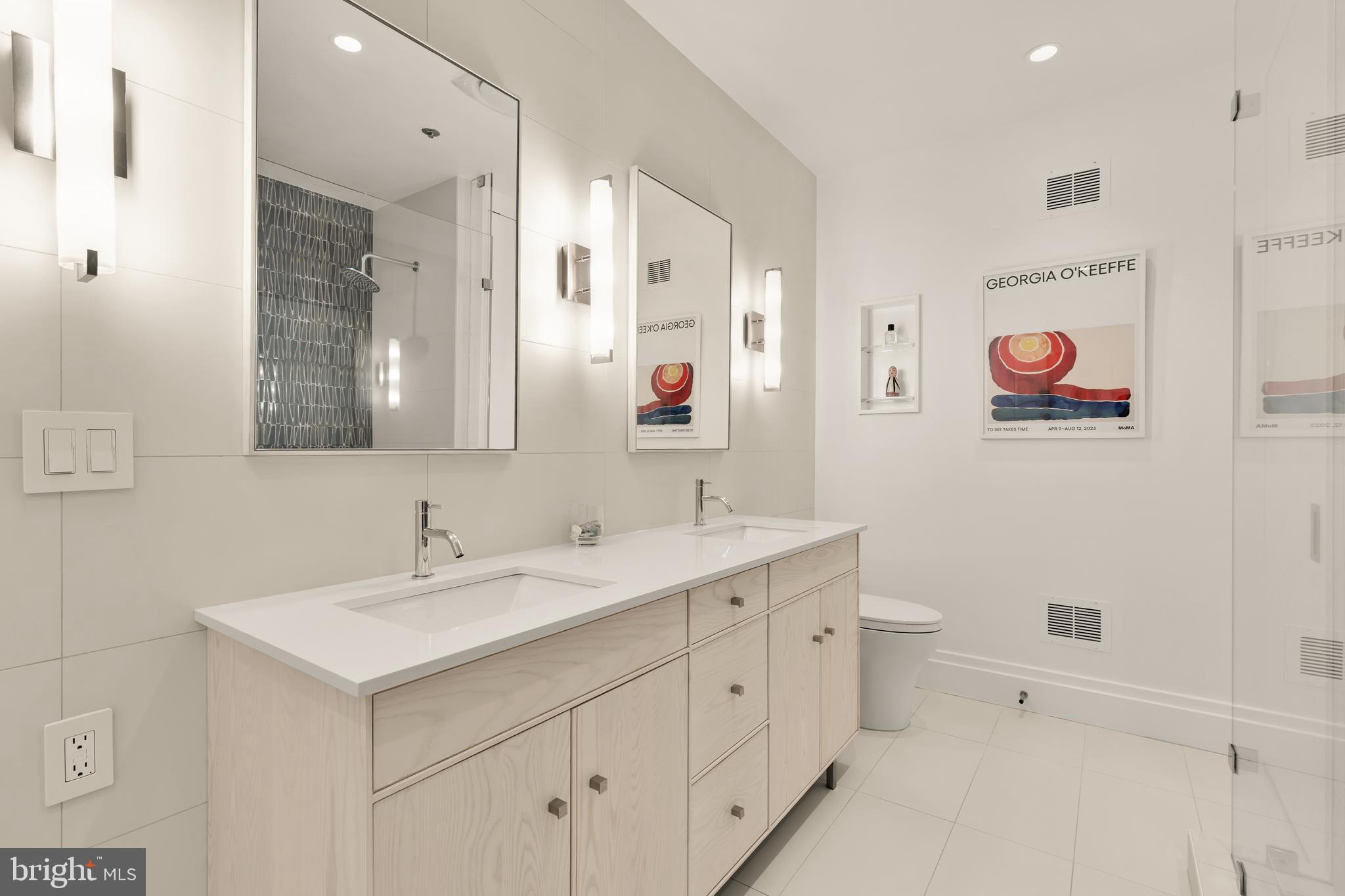7449 Arlington Road Bethesda, MD 20814 - Photo 22 of 35 a bathroom with a double vanity sink mirror and toilet