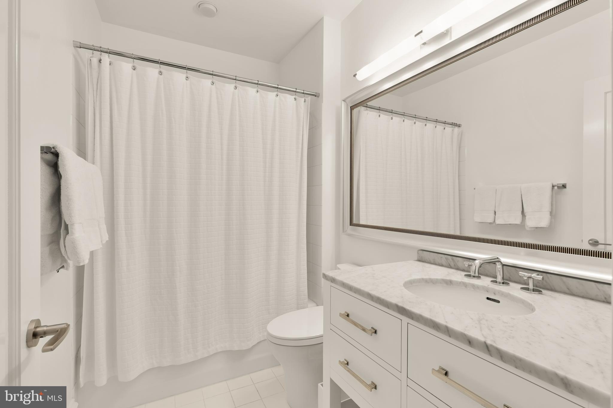 7449 Arlington Road Bethesda, MD 20814 - Photo 29 of 35 a bathroom with a double vanity sink toilet and a mirror