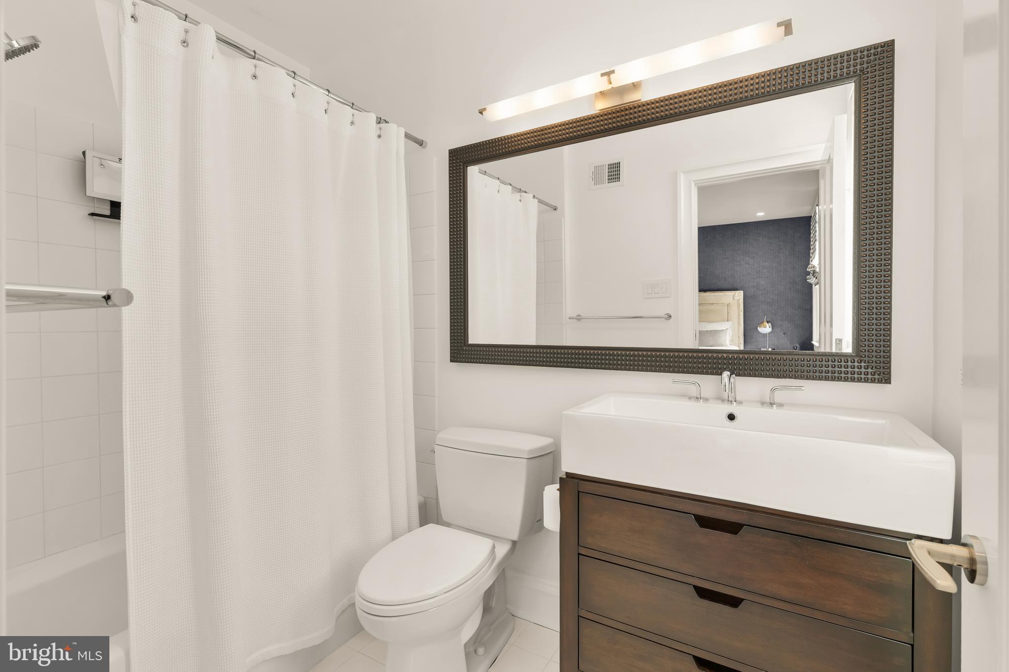 7449 Arlington Road Bethesda, MD 20814 - Photo 33 of 35 a bathroom with a sink mirror vanity and toilet