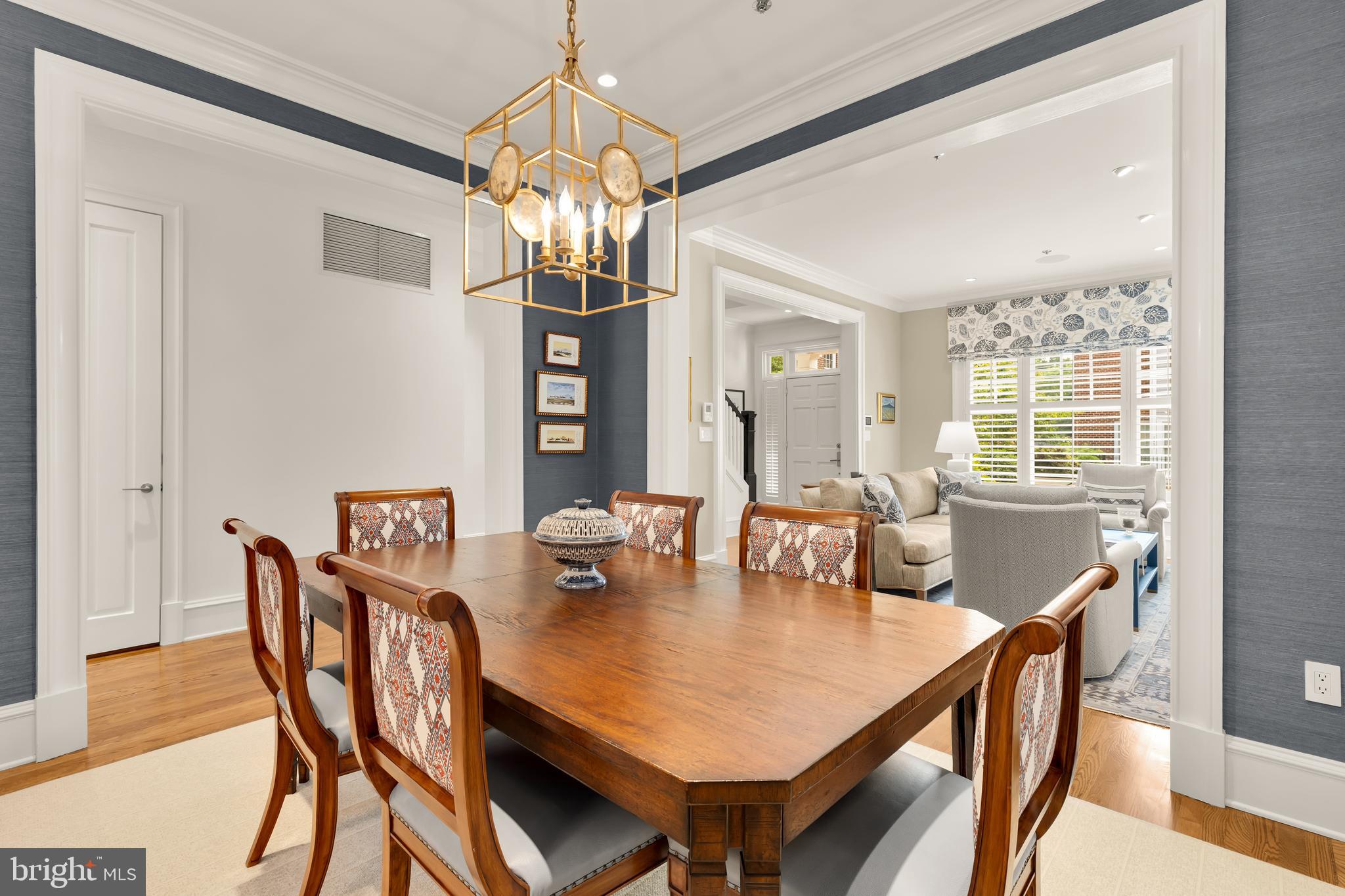7449 Arlington Road Bethesda, MD 20814 - Photo 7 of 35 a view of a dining room with furniture a chandelier and wooden floor