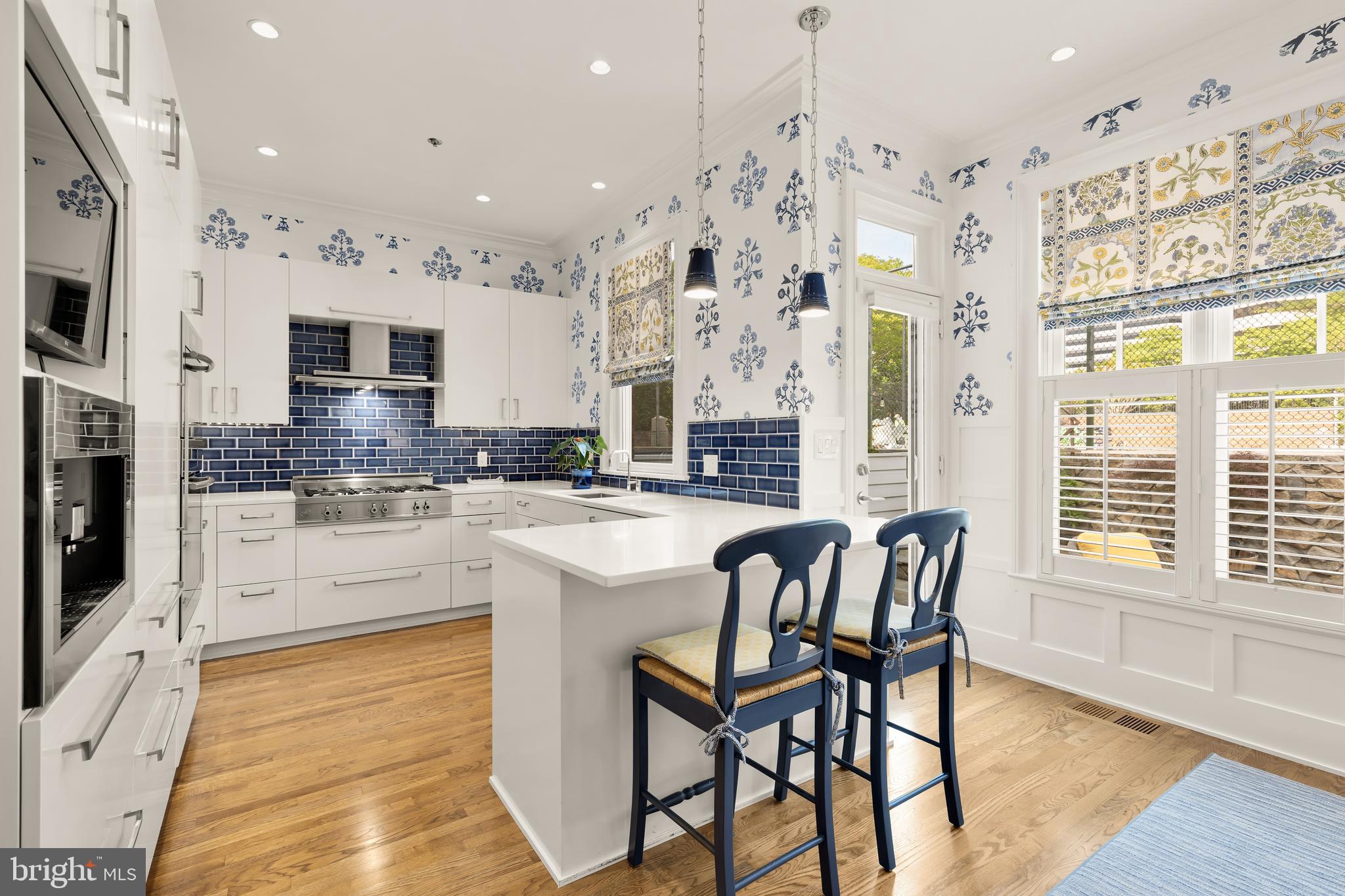 7449 Arlington Road Bethesda, MD 20814 - Photo 10 of 35 a kitchen with stainless steel appliances granite countertop a stove top oven a sink a dining table and chairs with wooden floor
