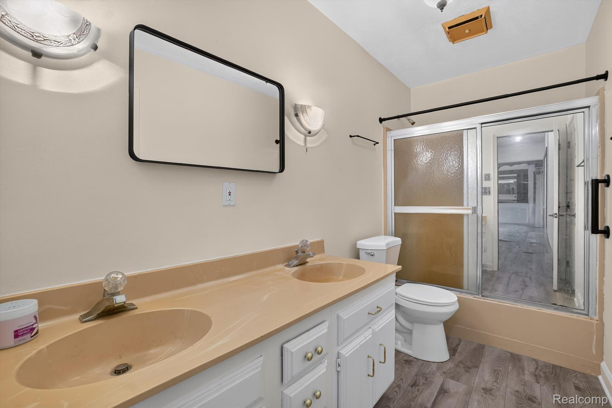 3760 Webberville Road North Williamston, MI 48895 - Photo 17 of 80 Bathroom featuring a dual-sink vanity with an integrated countertop, white cabinetry, and wood-finish flooring