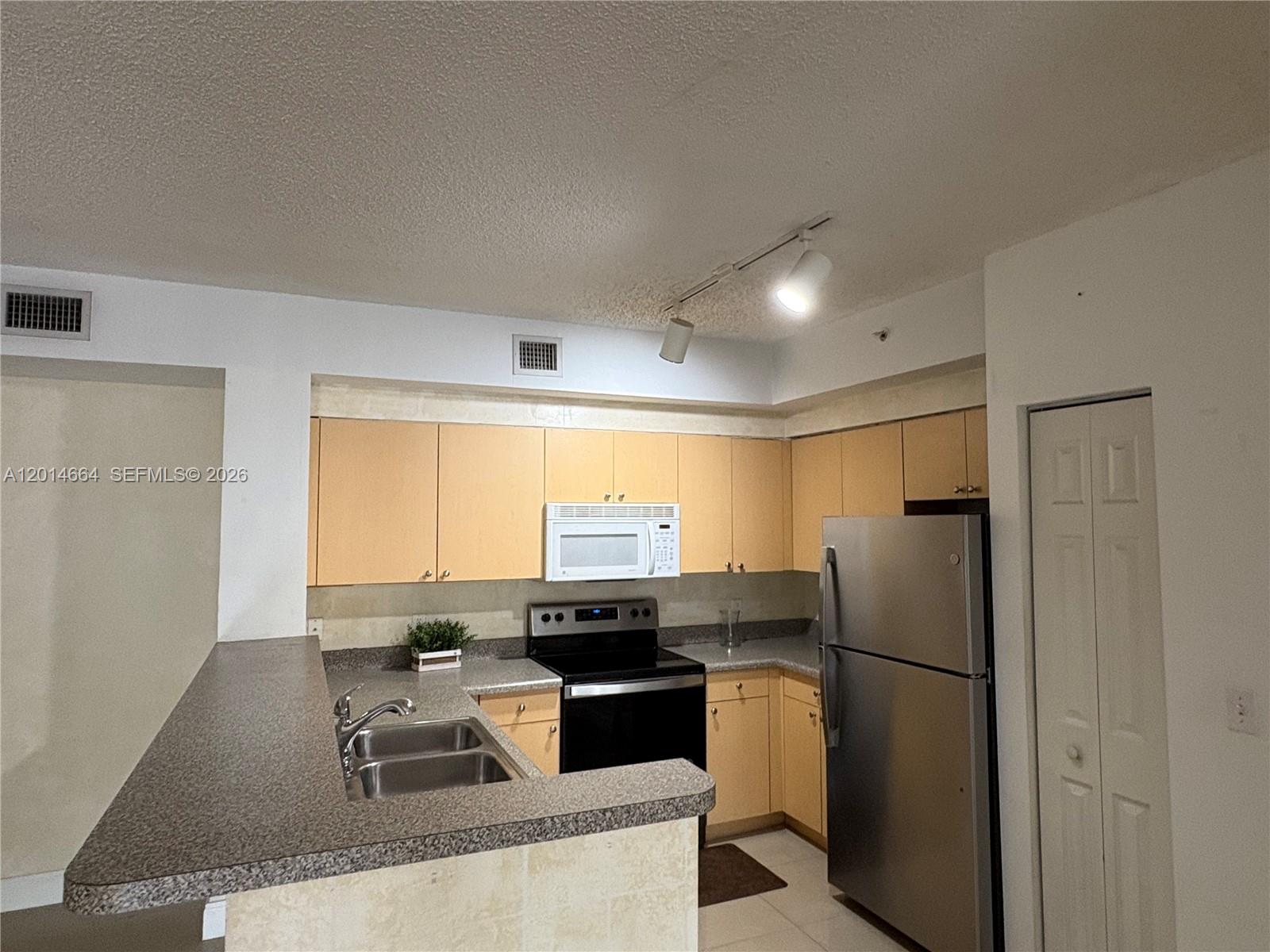 8030 North Nob Hill Road, Unit 105 Tamarac, FL 33321 - Photo 7 of 22 a kitchen with granite countertop a refrigerator and a stove top oven