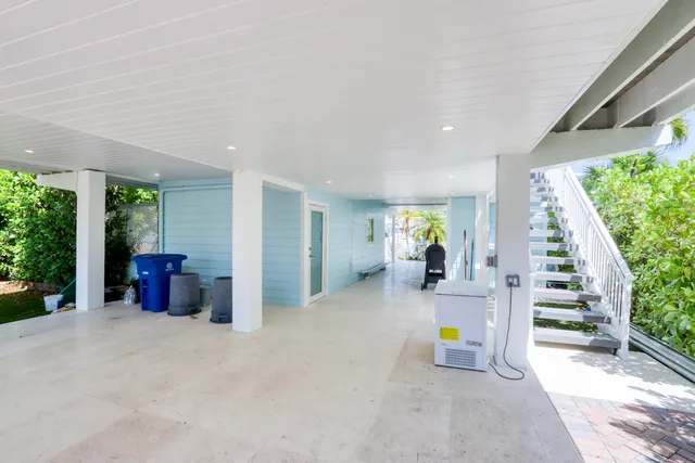 a living room with furniture a flat screen tv and kitchen view