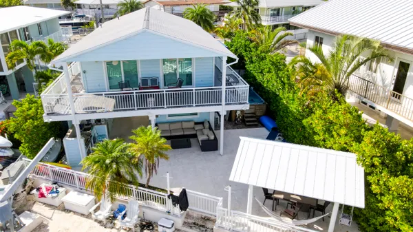 a dining hall with couches a flat tv screen and a dining table with garden view