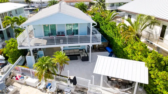 a dining hall with couches a flat tv screen and a dining table with garden view