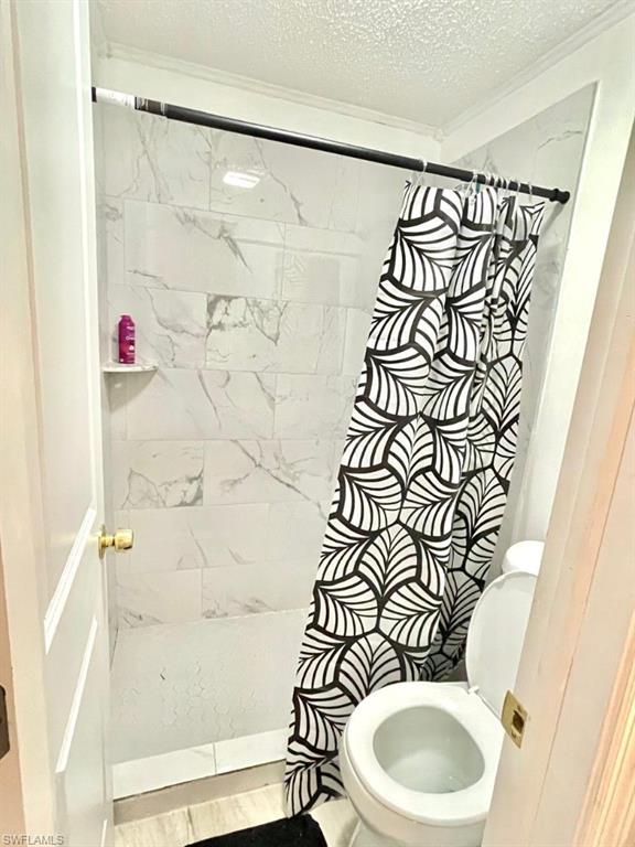 5385 Treetops Drive, Unit I Naples, FL 34113 - Photo 9 of 12 a bathroom with a toilet and a shower curtain