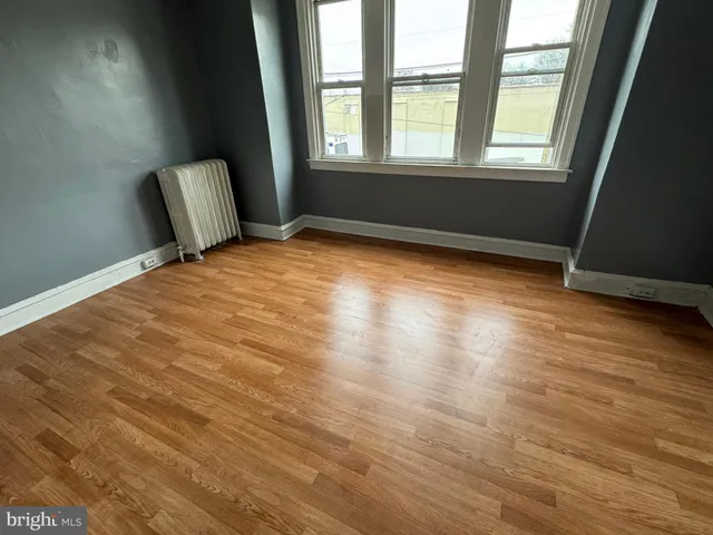 a view of room with window and wooden floor