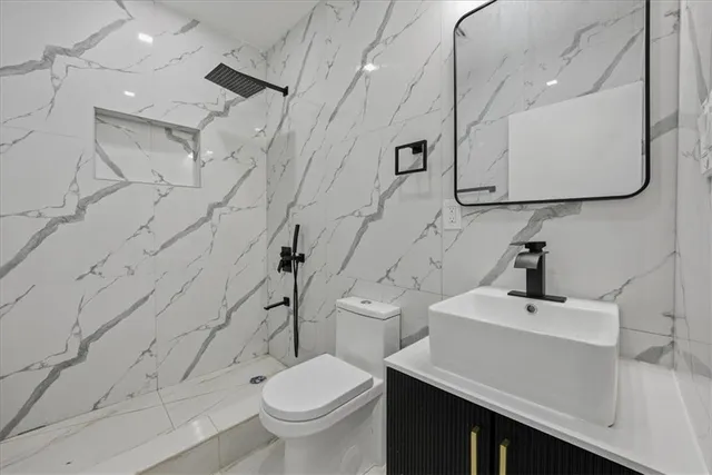 a bathroom with a sink a toilet and shower