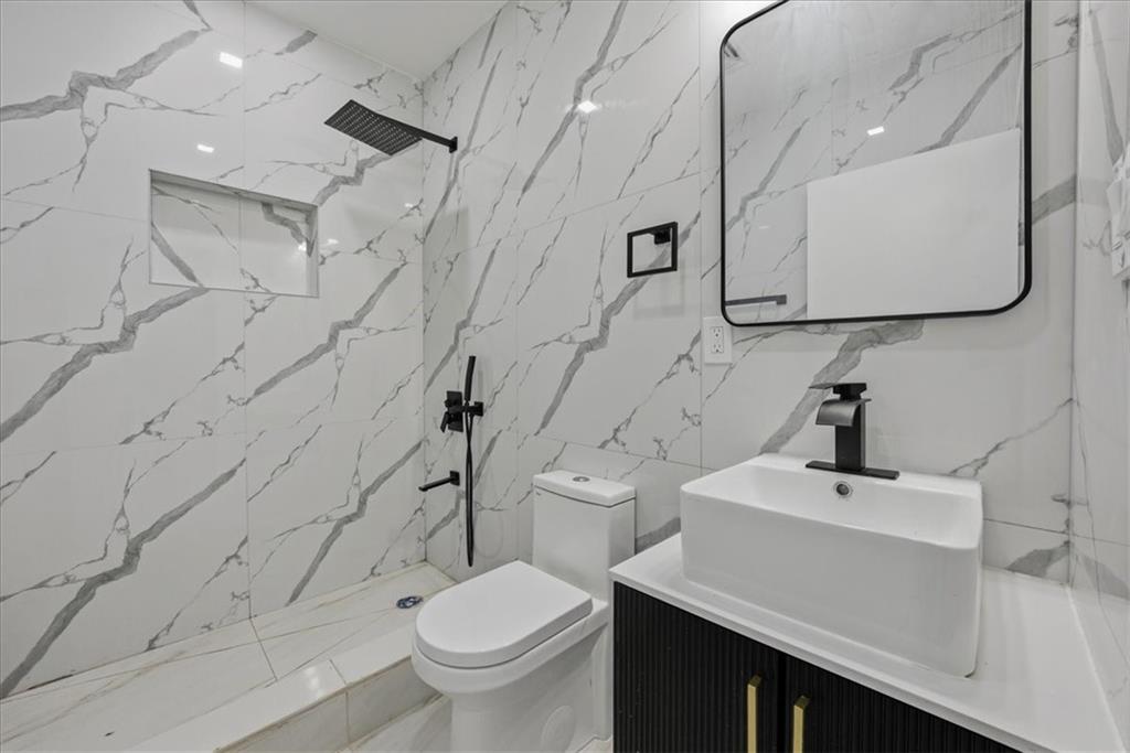 2862 Briggs Avenue Bronx, NY 10458 - Photo 13 of 38 a bathroom with a sink a toilet and shower