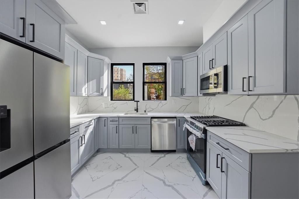 2862 Briggs Avenue Bronx, NY 10458 - Photo 18 of 38 a kitchen with granite countertop a sink stove refrigerator and cabinets