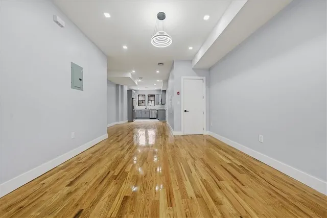 a view of empty room with wooden floor
