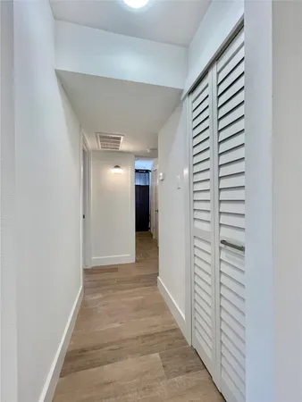 a view of a hallway with wooden shelves