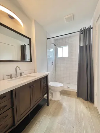 a bathroom with a toilet sink double vanity and mirror
