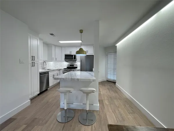 a kitchen with a sink cabinets and wooden floor