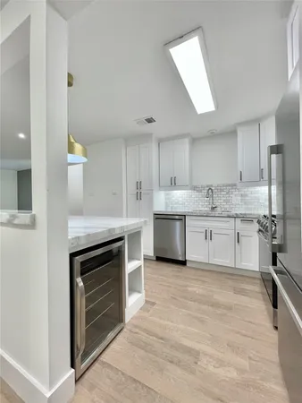 a large kitchen with stainless steel appliances granite countertop a stove sink and cabinets