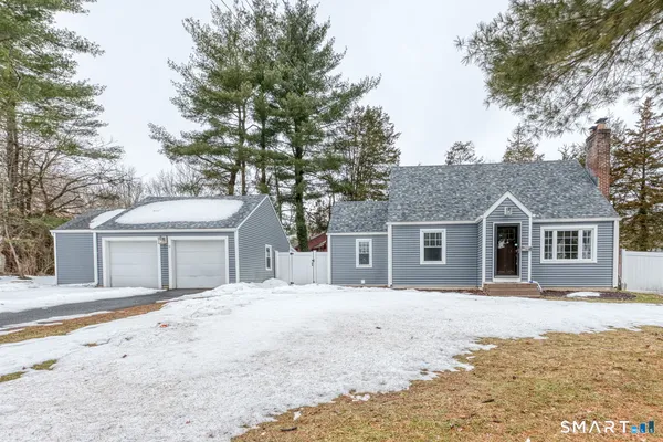 a front view of a house with a yard covered in snow