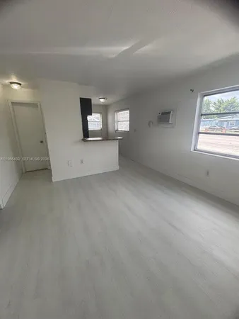 an empty room with windows and fireplace
