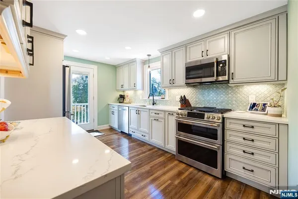 a bathroom with a granite countertop sink a toilet and a mirror