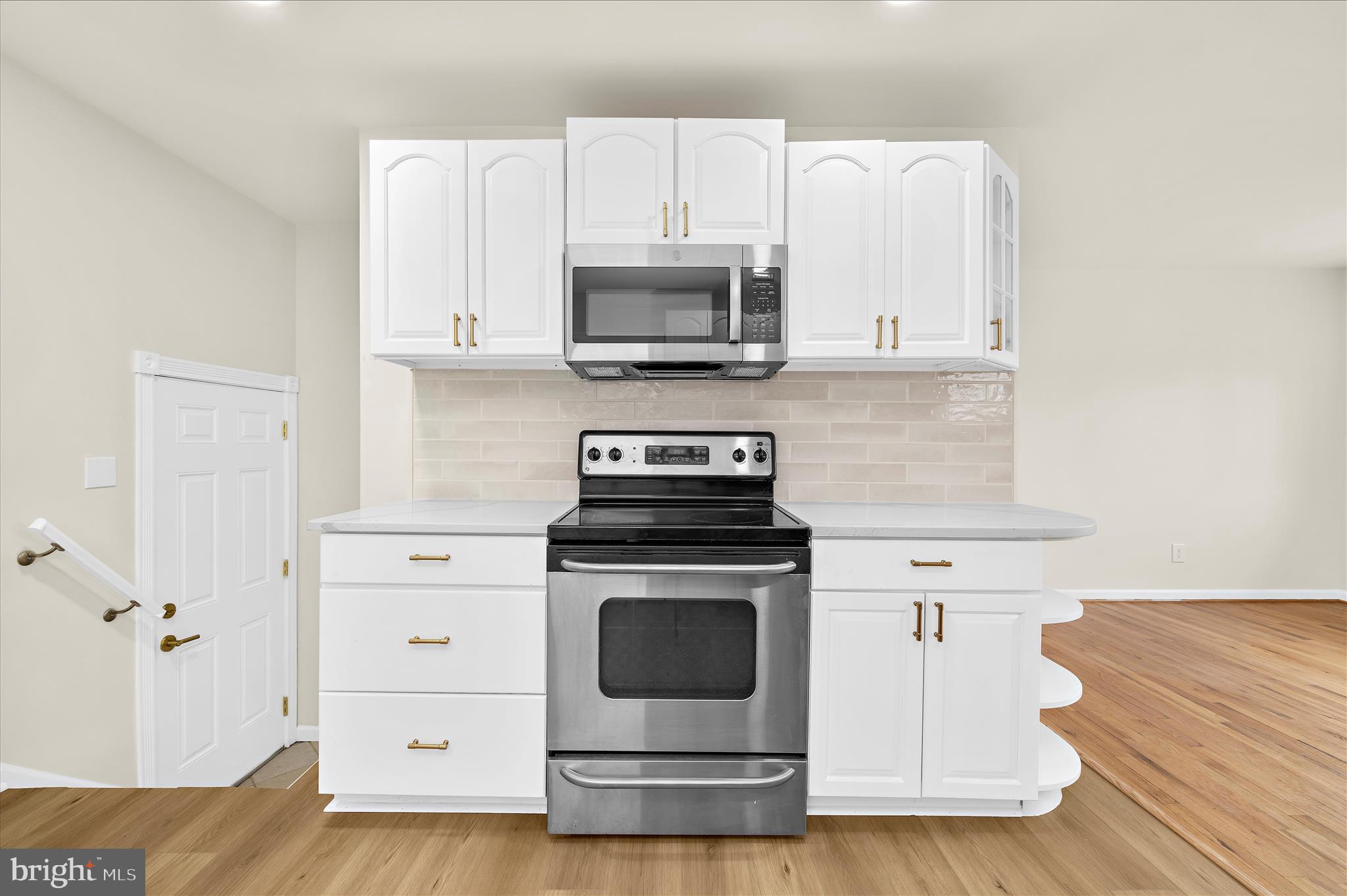 7831 Overhill Road Glen Burnie, MD 21060 - Photo 11 of 57 a kitchen with granite countertop a stove top oven and cabinets