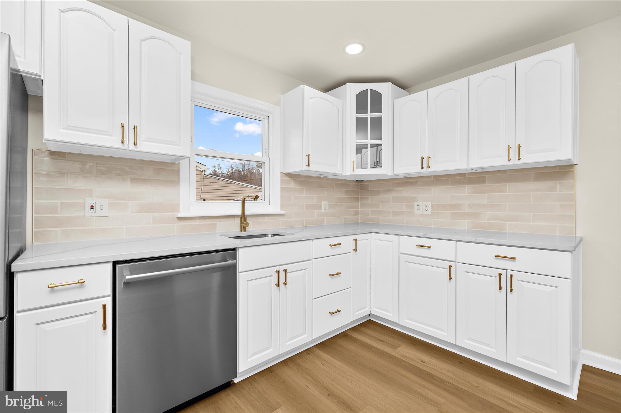 7831 Overhill Road Glen Burnie, MD 21060 - Photo 12 of 57 a kitchen with white cabinets white appliances and sink