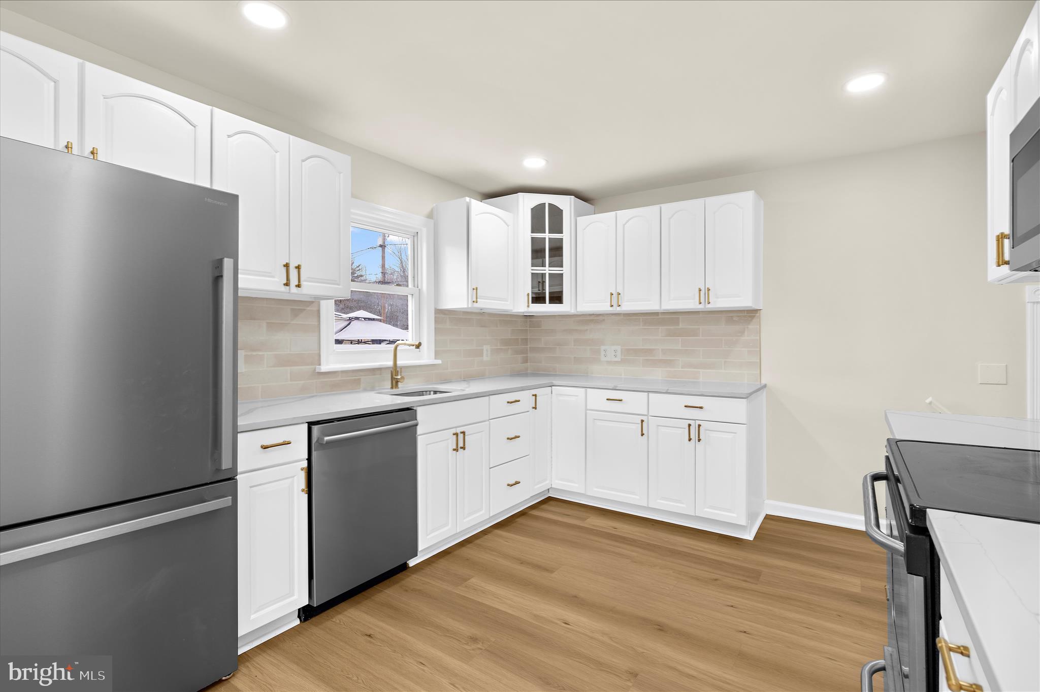 7831 Overhill Road Glen Burnie, MD 21060 - Photo 9 of 57 a kitchen with granite countertop white cabinets and white appliances