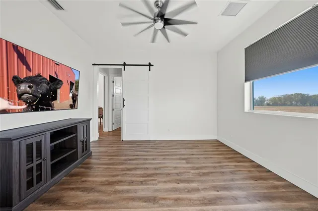 a view of a livingroom with wooden floor and a fireplace