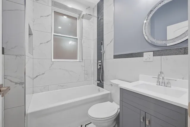 a bathroom with a bathtub shower sink vanity and a toilet