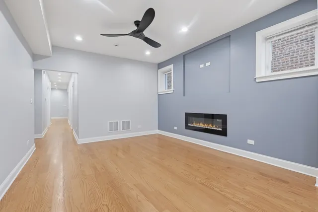 a view of a livingroom with a ceiling fan a hardwood floor and a ceiling fan