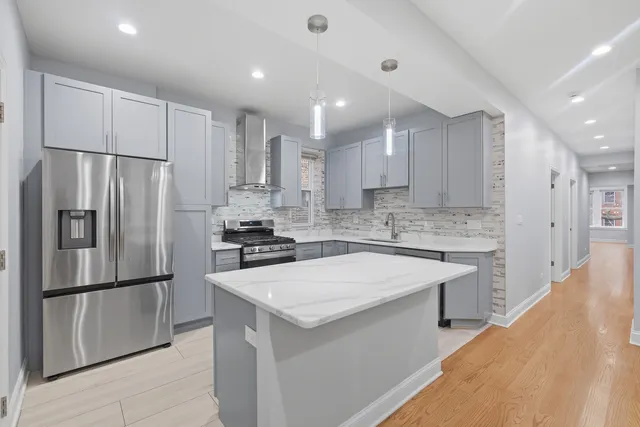a kitchen with a refrigerator a sink and white cabinets