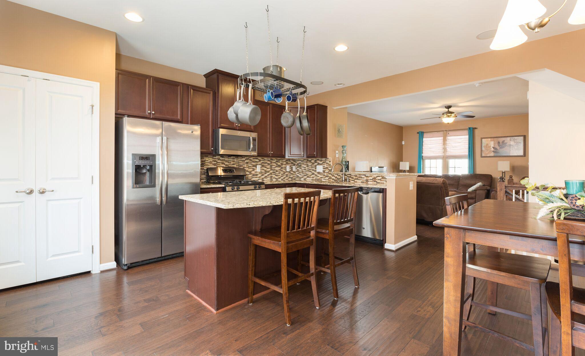108 Brenton Road Fredericksburg, VA 22405 - Photo 7 of 24 a kitchen with stainless steel appliances granite countertop a stove a refrigerator a sink a dining table and chairs with wooden floor
