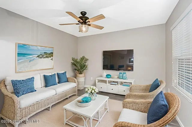 a living room with furniture a flat screen tv and a window