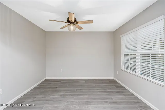 a view of a room with wooden floor and windows