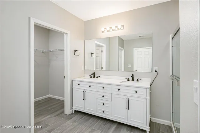 a bathroom with a double vanity sink and mirror