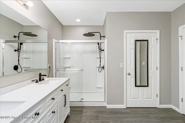 a bathroom with a double vanity sink mirror and shower