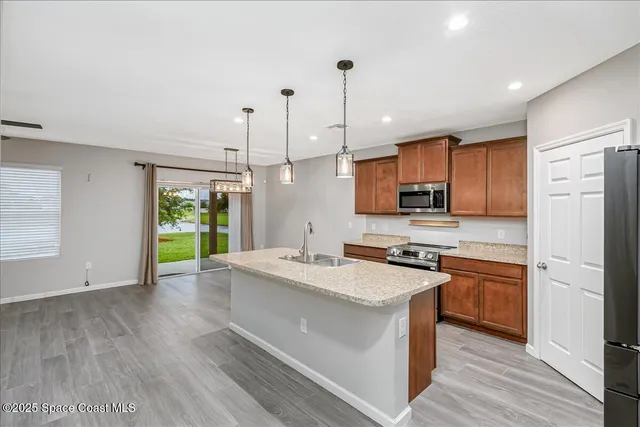 a kitchen with stainless steel appliances granite countertop a sink a stove and a refrigerator