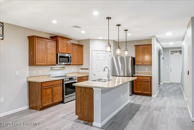 a kitchen with stainless steel appliances granite countertop a sink stove and refrigerator